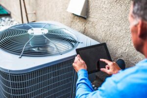 HVAC-contrator-diagnosing-air-conditioning-unit