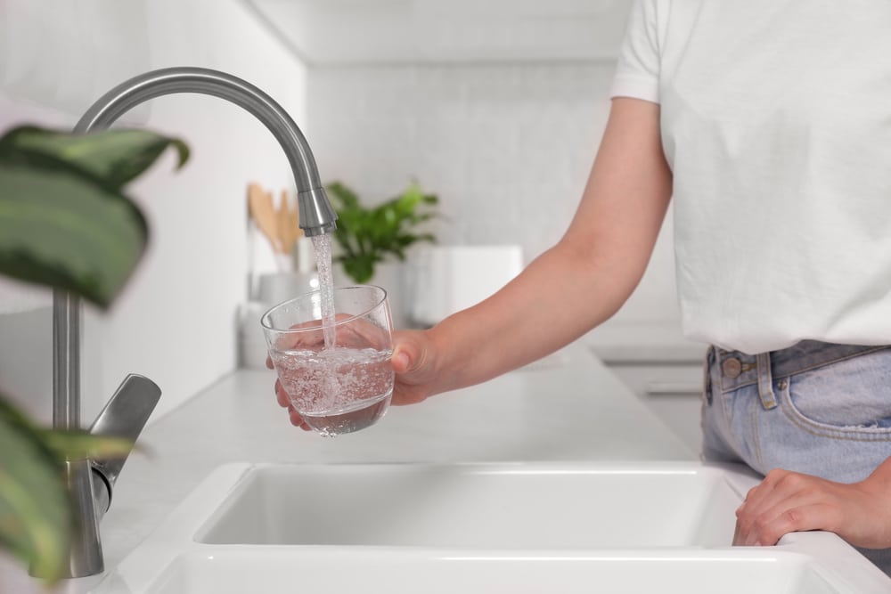 Woman,Filling,Glass,With,Water,From,Tap,In,Kitchen,,Closeup